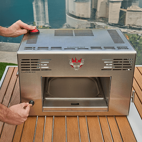 A real Schwank portable infrared grill being ignited on a stable outdoor table